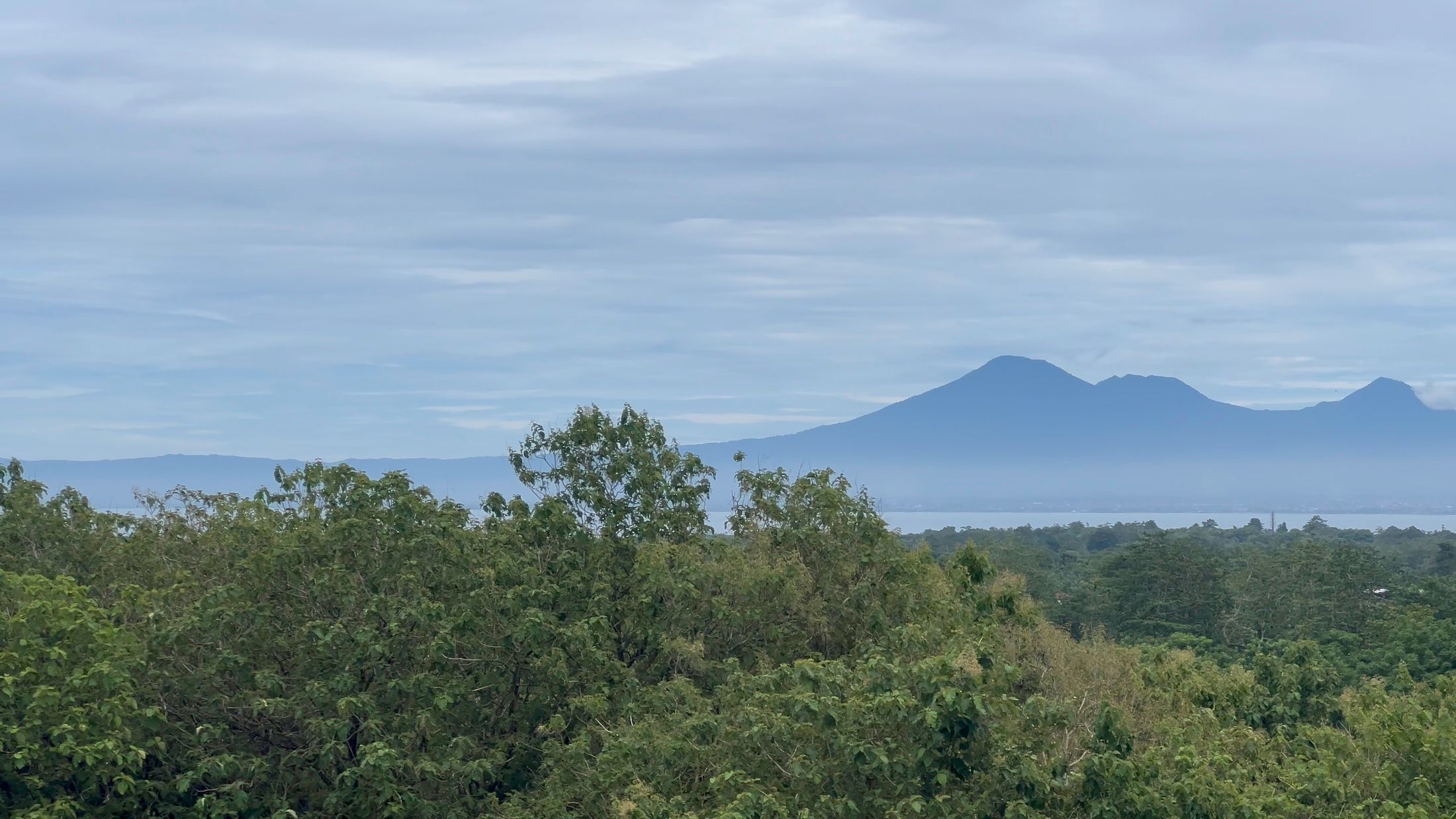 The outlook panning on: jungle below and a volcano rising on the far horizon.
