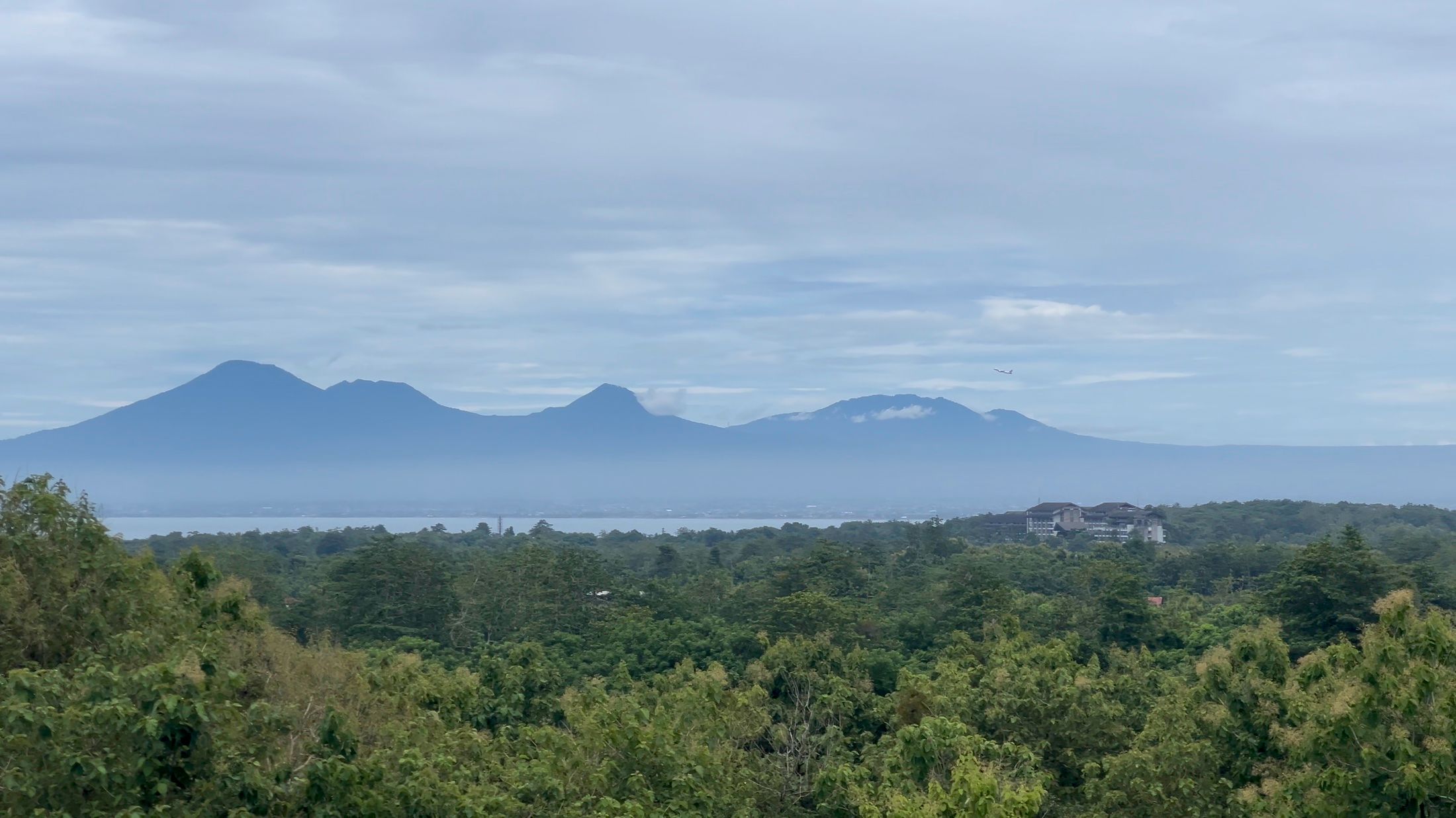 The heart of the view: jungle, then a band of sea, then the line of volcanoes on the mainland.